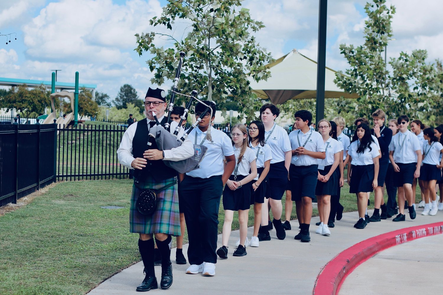 A bagpiper leads a group of students at the British International School of Houston, 2203 N. Westgreen Blvd., to an on-campus commemorative thanksgiving event honoring the life of Queen Elizabeth II of the United Kingdom. Events included a special assembly and a tree-planting ceremony where students and staff laid down flowers in the queen’s memory. The queen’s funeral was held Monday in London.